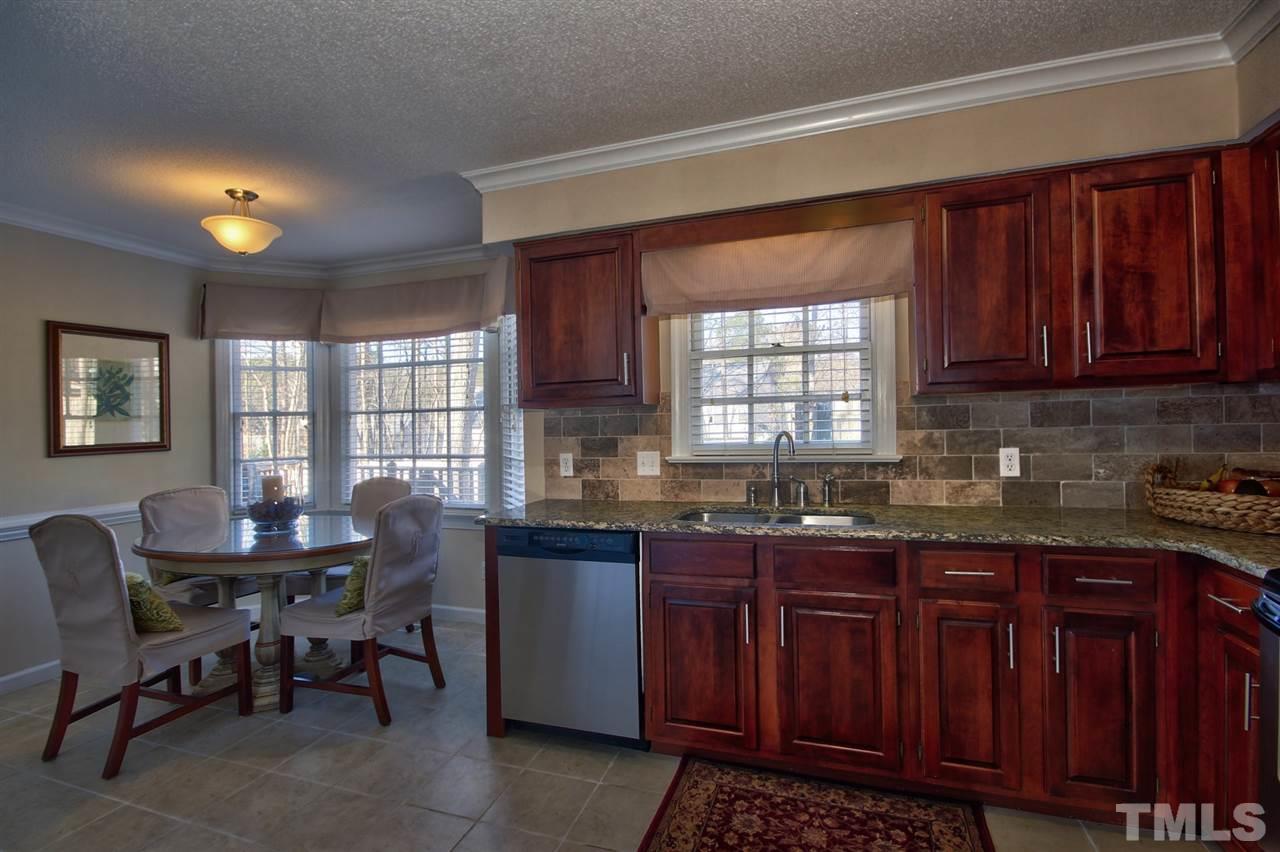 7141 Kinross Drive Raleigh, NC 27613 - Photo 6 of 19 a kitchen with granite countertop a sink cabinets and window