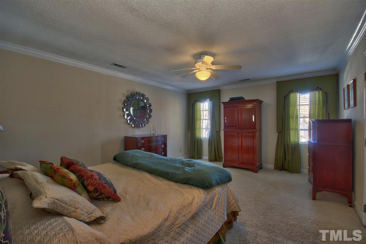7141 Kinross Drive Raleigh, NC 27613 - Photo 10 of 19 a bedroom with a bed and a chandelier