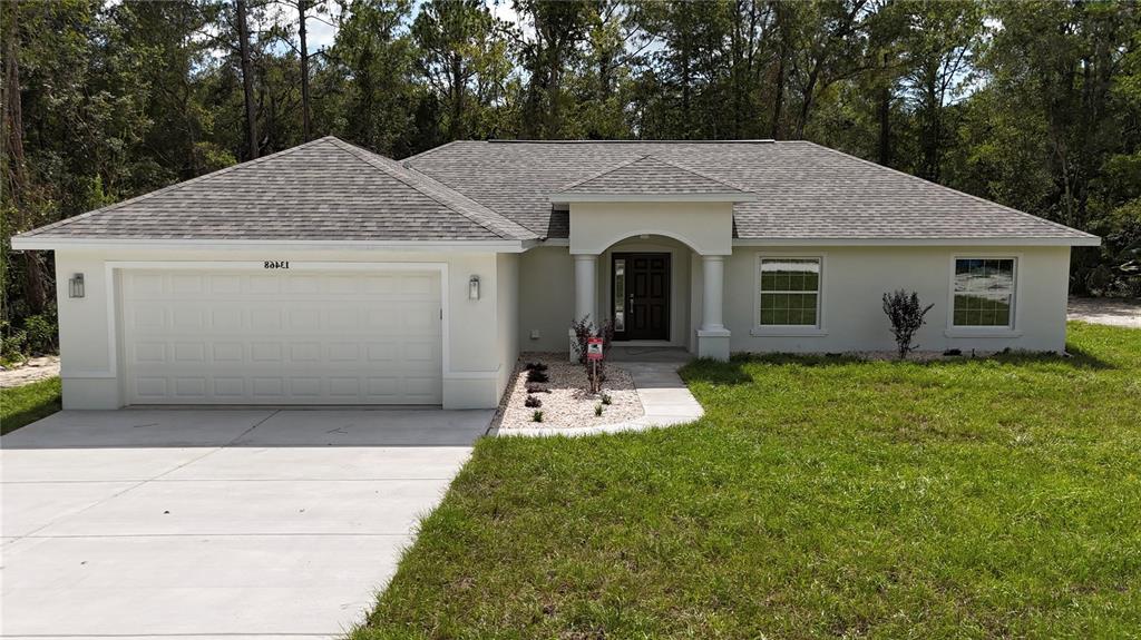 15333 Honeycreeper Road Brooksville, FL 34614 - Photo 1 of 19 a front view of a house with garden