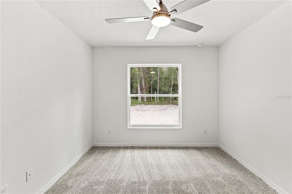 15333 Honeycreeper Road Brooksville, FL 34614 - Photo 15 of 19 an empty room with a window and a fan
