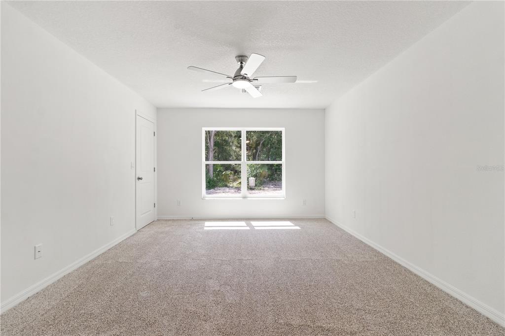 15333 Honeycreeper Road Brooksville, FL 34614 - Photo 7 of 19 an empty room with windows and ceiling fan