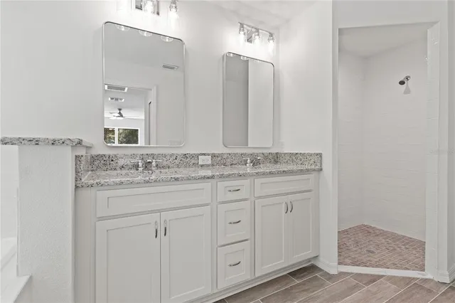 a bathroom with a granite countertop sink and a mirror