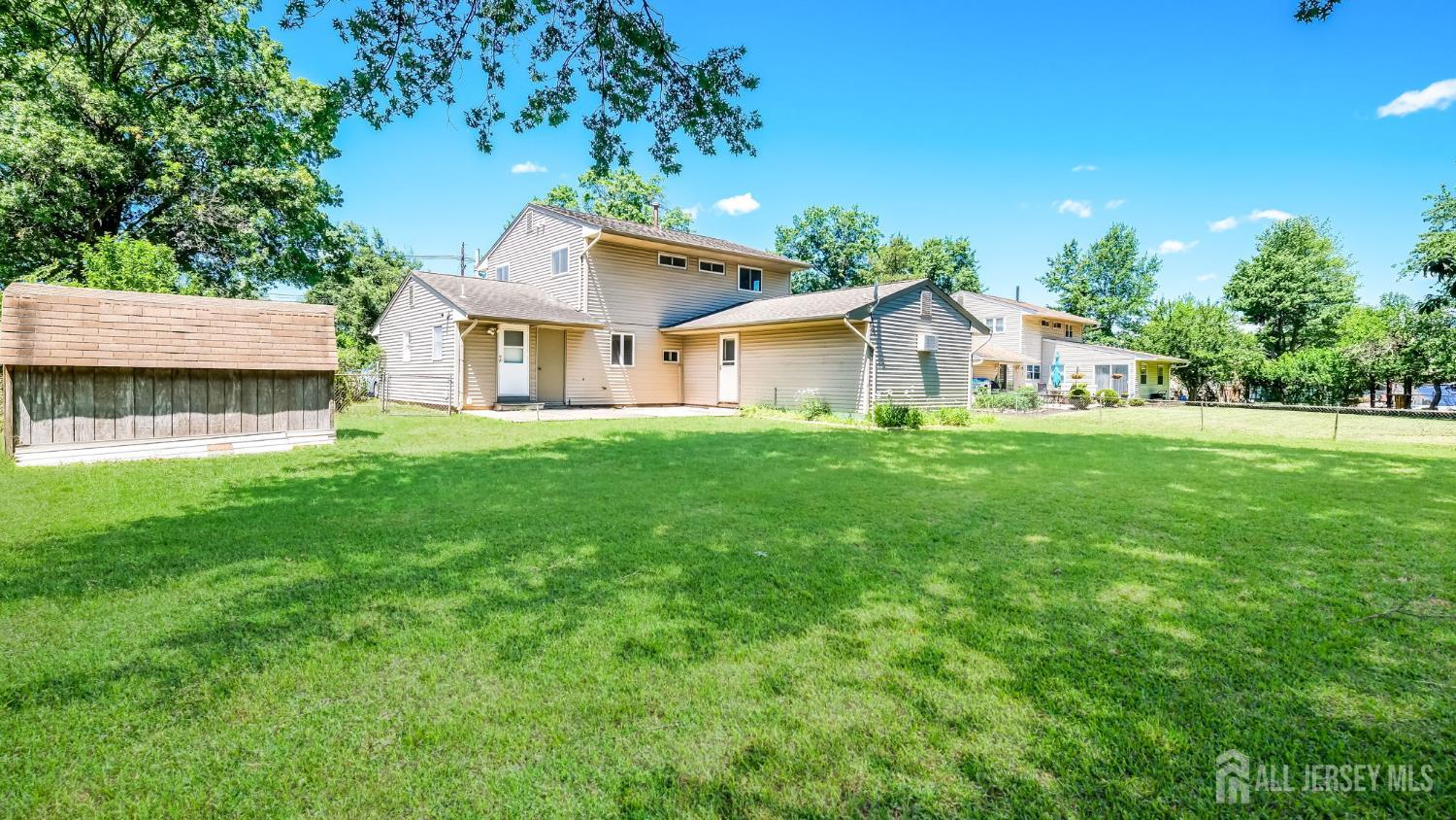 50 Sand Hills Road Kendall Park, NJ 08824 - Photo 23 of 27 a view of a house with a big yard and large trees