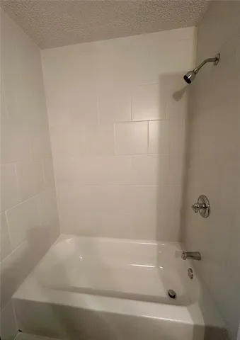 an empty room with a chandelier fan and windows