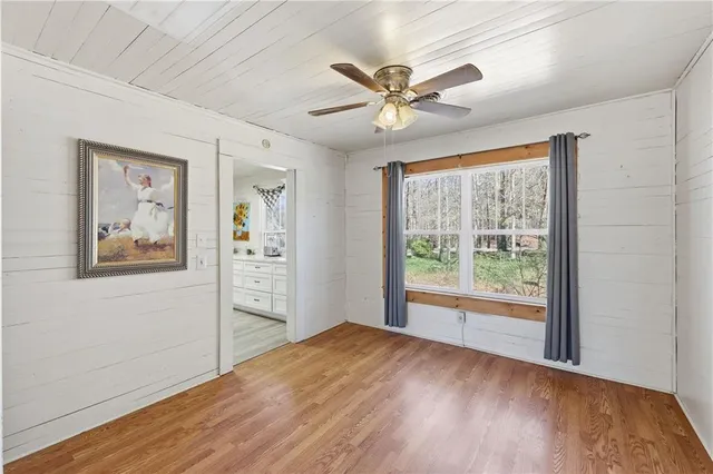 a view of a big room with wooden floor and windows