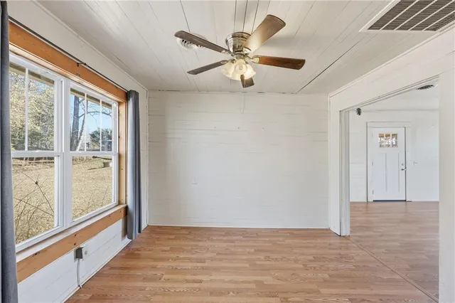 an empty room with fan and windows