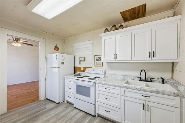 a kitchen with white cabinets and white appliances
