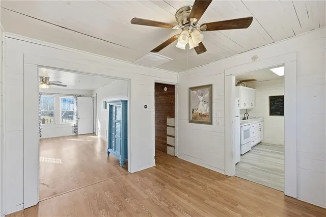 a view of a big room with wooden floor and a ceiling fan