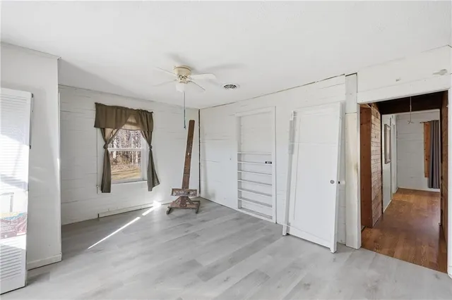 a view of a room with wooden floor and windows