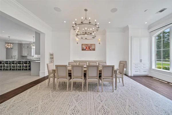 a dining room with furniture a chandelier and wooden floor
