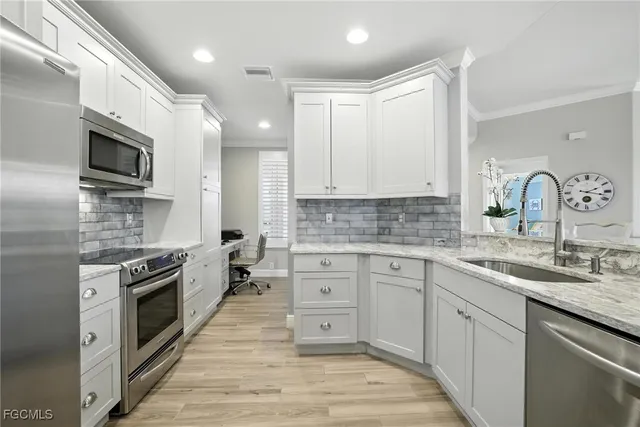 a kitchen with granite countertop a sink stainless steel appliances and cabinets