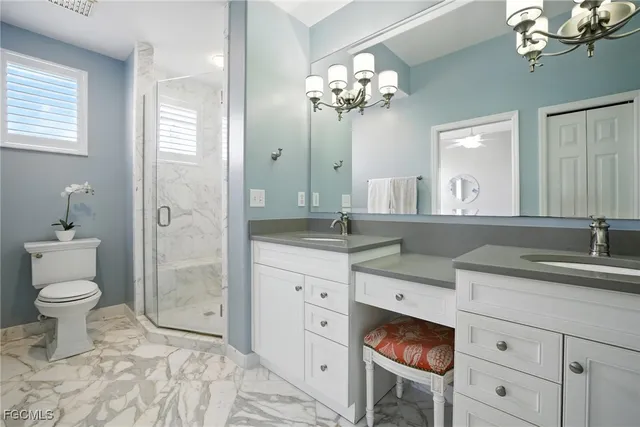 a spacious bathroom with a granite countertop sink a toilet and a mirror
