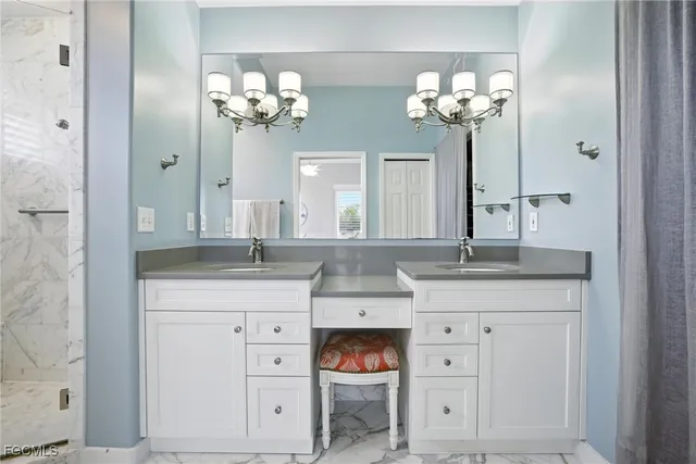 a bathroom with a granite countertop white cabinets and a sink
