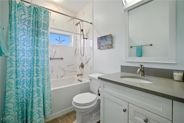 a bathroom with a granite countertop sink a toilet and shower