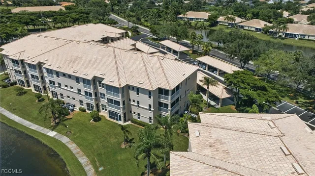 aerial view of a house with a yard and large trees
