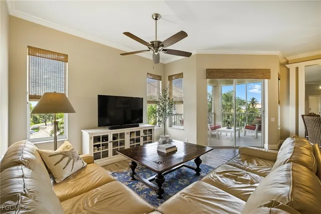 a living room with furniture a flat screen tv and a large window
