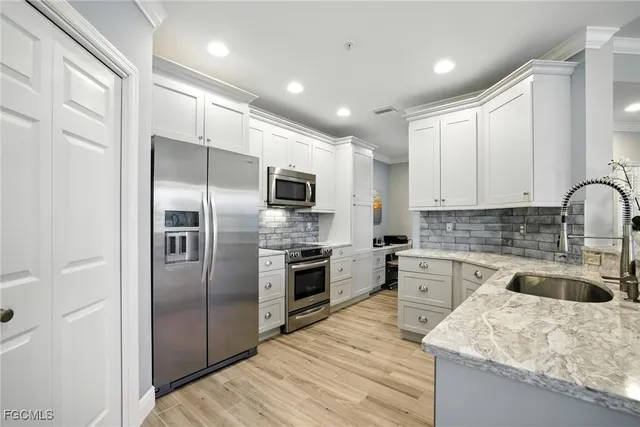 a kitchen with stainless steel appliances granite countertop a refrigerator and a stove top oven