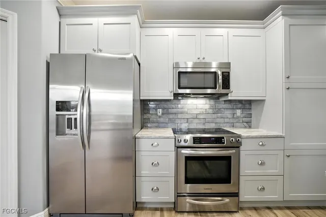 a kitchen with stainless steel appliances a stove a microwave and a refrigerator