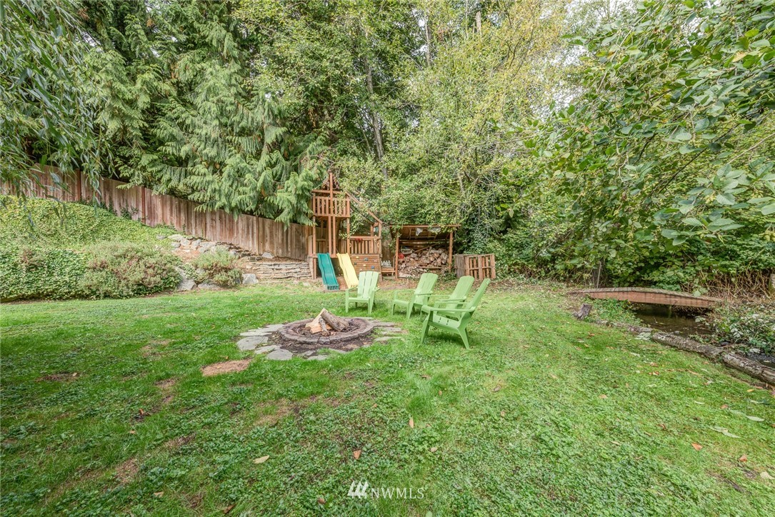 2633 189th Street Southeast Bothell, WA 98012 - Photo 18 of 35 a view of a backyard with table and chairs and wooden fence