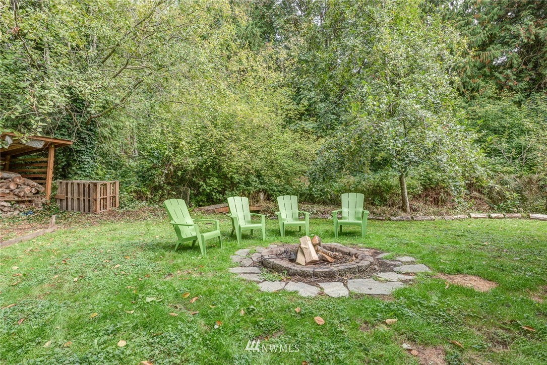 2633 189th Street Southeast Bothell, WA 98012 - Photo 19 of 35 a view of a backyard with table and chairs and wooden fence