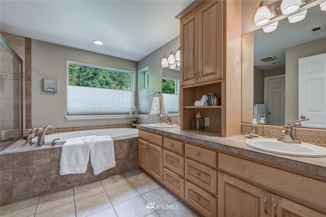 2633 189th Street Southeast Bothell, WA 98012 - Photo 28 of 35 a bathroom with a double vanity sink a mirror and a bathtub
