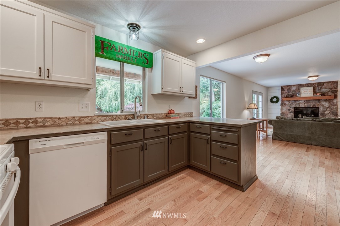 2633 189th Street Southeast Bothell, WA 98012 - Photo 7 of 35 a kitchen with kitchen island granite countertop wooden floors and sink