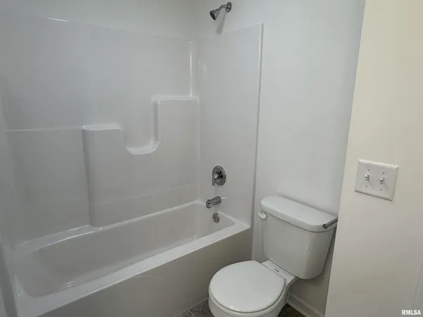 a white toilet and tub sitting next to a bathroom sink