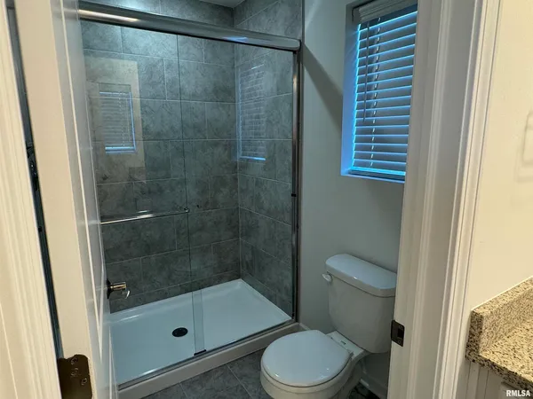 a bathroom with a shower a toilet and a sink