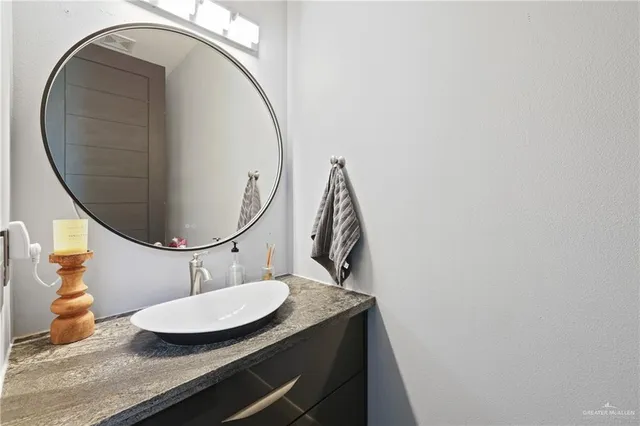 a bathroom with a granite countertop sink and a mirror