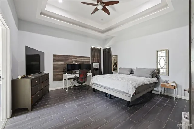 a spacious bedroom with a bed and a flat screen tv