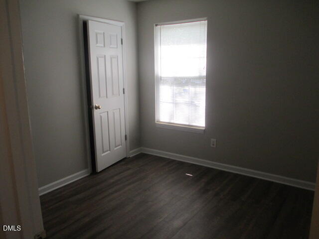 5409 Botany Bay Drive Raleigh, NC 27616 - Photo 8 of 14 an empty room with wooden floor and windows with curtains