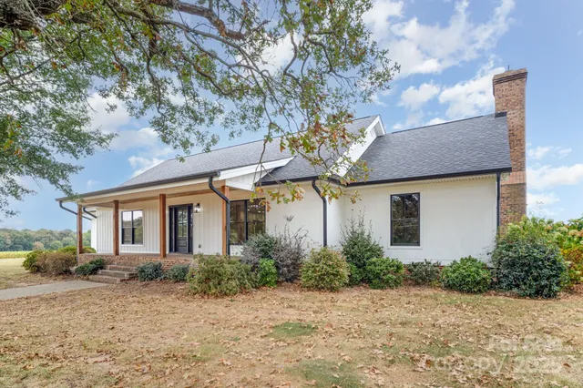 a front view of house with yard and trees around