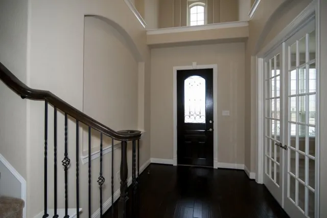 a view of a hallway with wooden floor and stairs