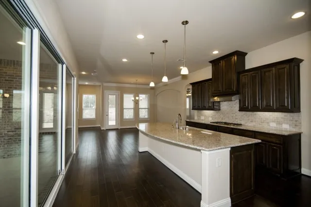 a kitchen with stainless steel appliances granite countertop a sink a stove and a refrigerator