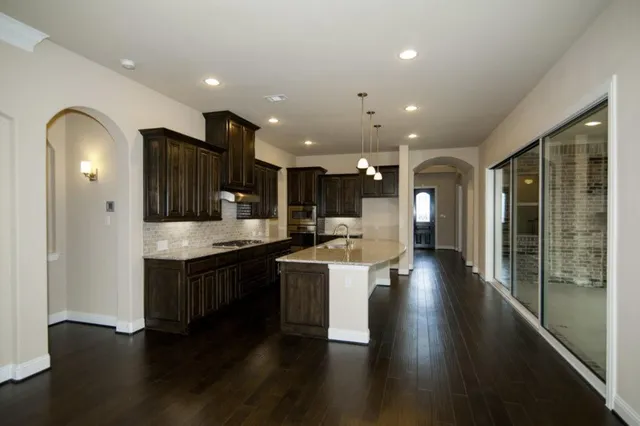 a open kitchen with stainless steel appliances granite countertop a lot of counter space and wooden floor