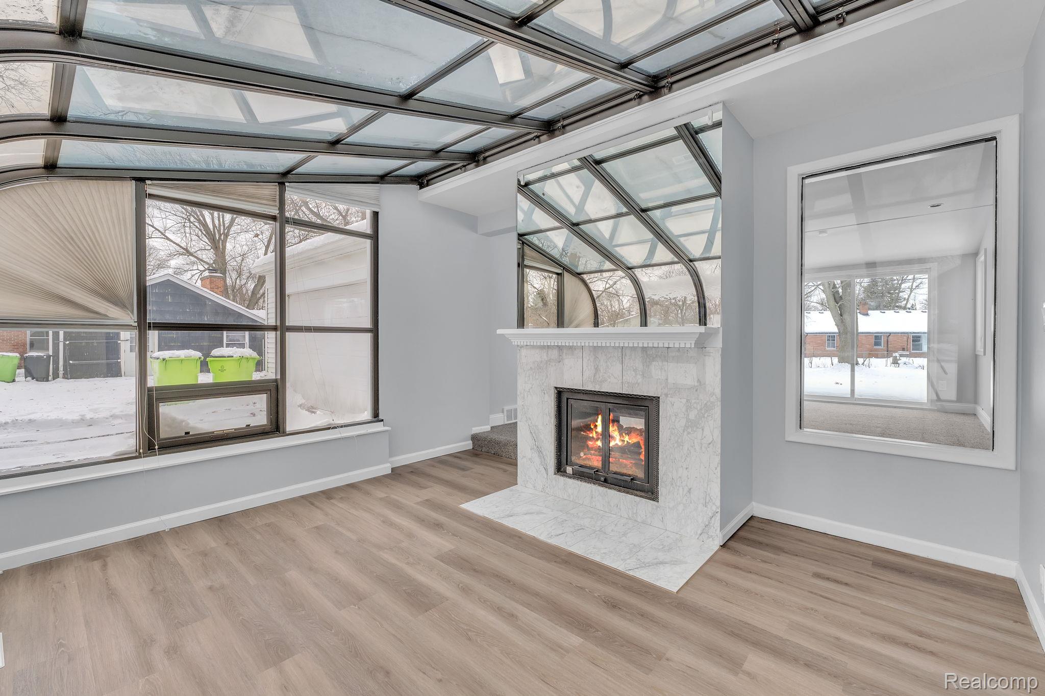 6576 Inkster Road West Bloomfield, MI 48322 - Photo 21 of 62 Unfurnished living room with a fireplace and light wood-type flooring