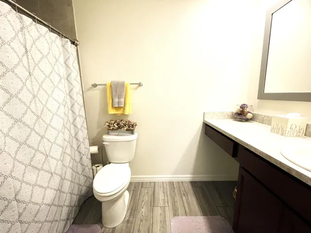 a bedroom with a bed and a flat tv screen on dresser