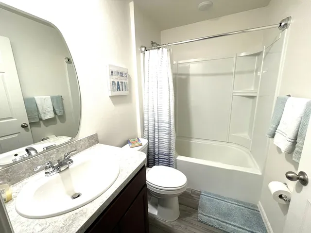 a bathroom with a granite countertop sink toilet and mirror