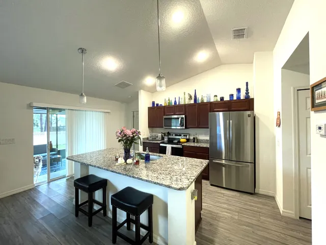 a view of a dining room with furniture a chandelier and wooden floor