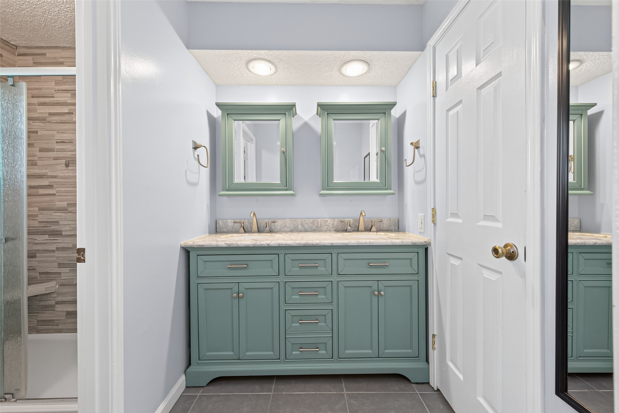 17531 Crestline Road Humble, TX 77396 - Photo 29 of 41 Elegant primary bathroom featuring a dual-sink vanity, stylish mirrors, and a modern walk-in shower.