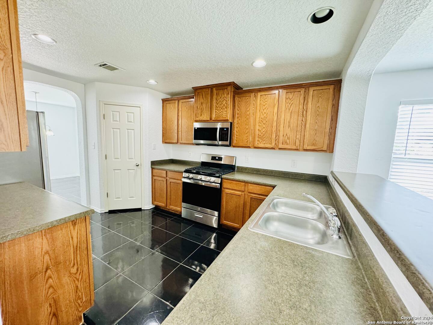 12139 Patton Point San Antonio, TX 78254 - Photo 11 of 34 a kitchen with stainless steel appliances granite countertop a stove a sink and a refrigerator