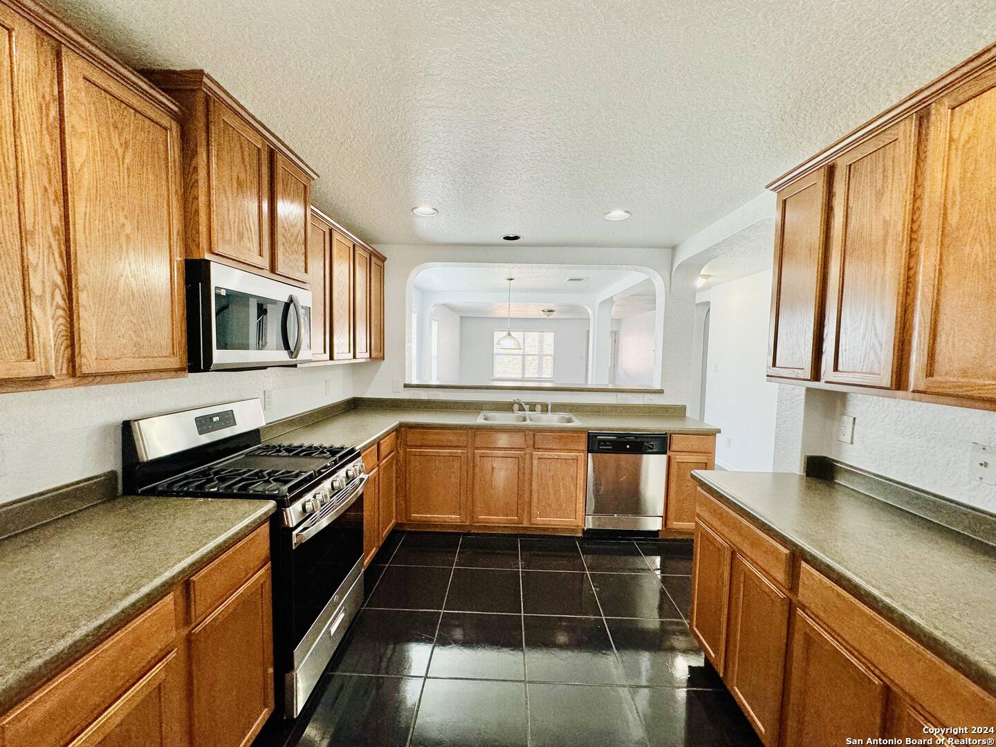 12139 Patton Point San Antonio, TX 78254 - Photo 9 of 34 a kitchen with stainless steel appliances a stove sink and cabinets