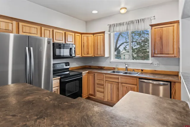 a kitchen with stainless steel appliances granite countertop a refrigerator stove and sink