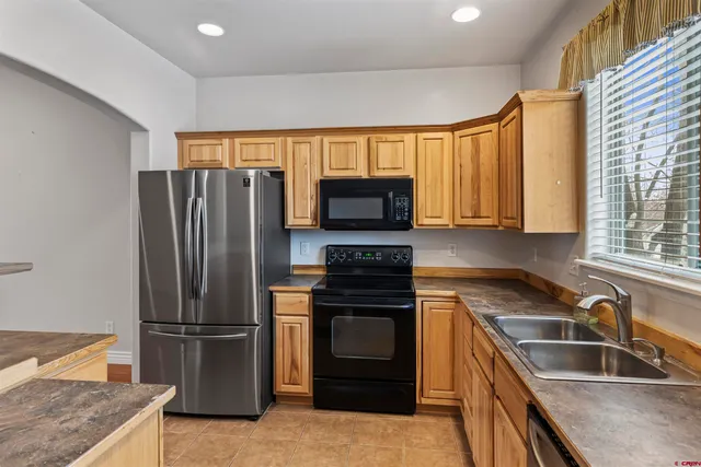a kitchen with granite countertop a refrigerator and a sink