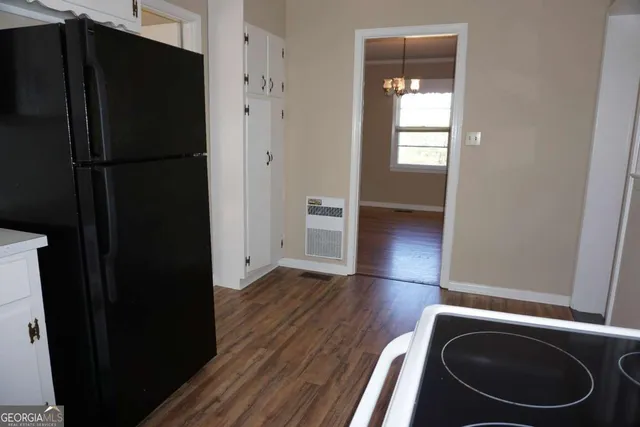 a kitchen with granite countertop wooden floors stainless steel appliances and sink