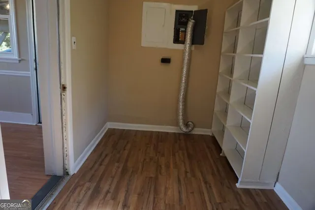 an empty room with wooden floor and entrance