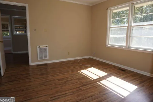 a view of empty room with wooden floor and windows