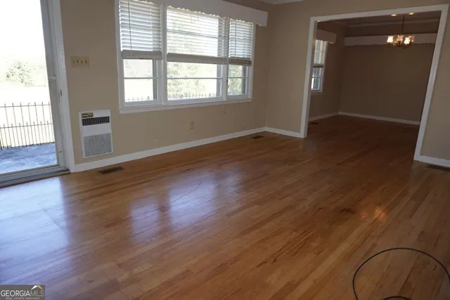 a view of an empty room with wooden floor and closet