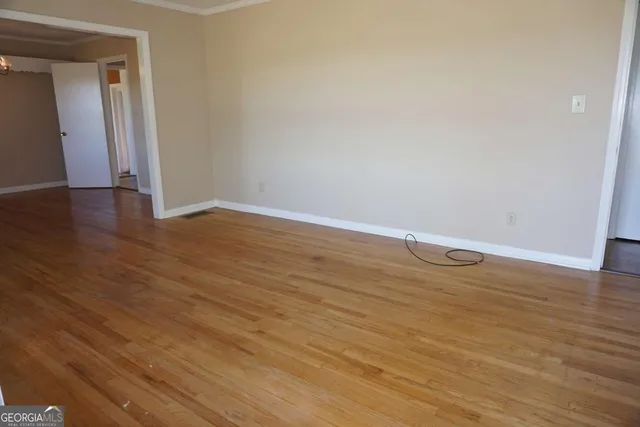 wooden floor in an empty room with a window