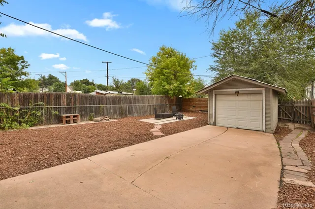 a front view of a house with a garden and trees